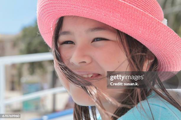 close up of a young girl enjoying sea breeze in a sailing boat. - girl blowing sand stock-fotos und bilder