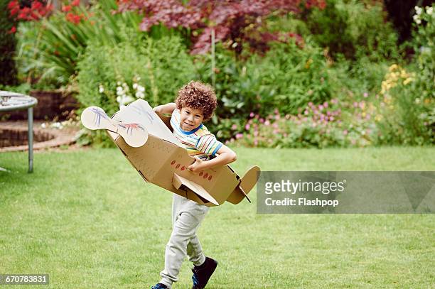 boy playing with cardboard aeroplane - day 6 stock-fotos und bilder