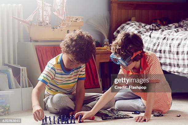 two children working together to make things - playing toy men stockfoto's en -beelden