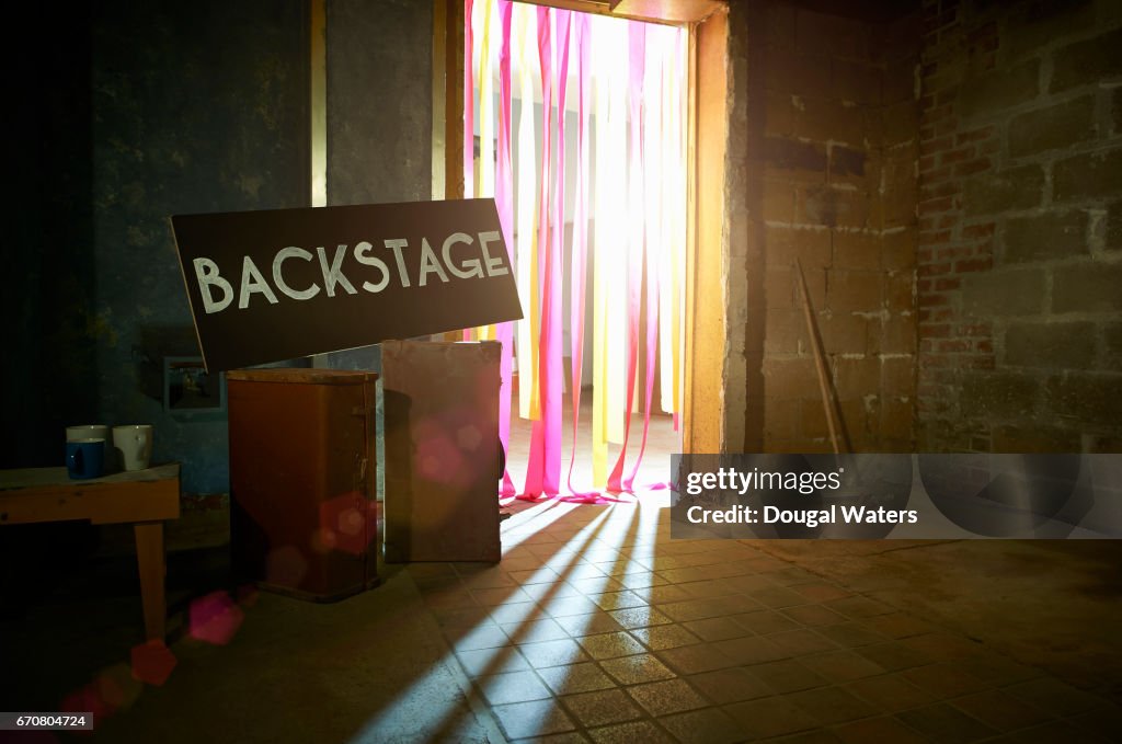 Backstage sign with spotlight through theatre doorway.