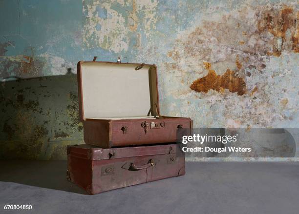 vintage suitcases in room with decaying wall. - nostalgia fotografías e imágenes de stock