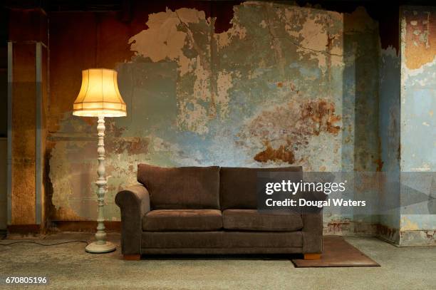 old sofa and vintage floor lamp in decaying room. - old wall foto e immagini stock