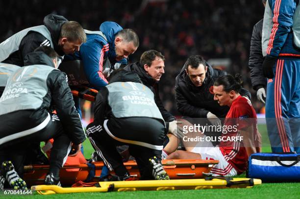 Manchester United's Swedish striker Zlatan Ibrahimovic gets treatment after injuring his knee during the UEFA Europa League quarter-final second leg...