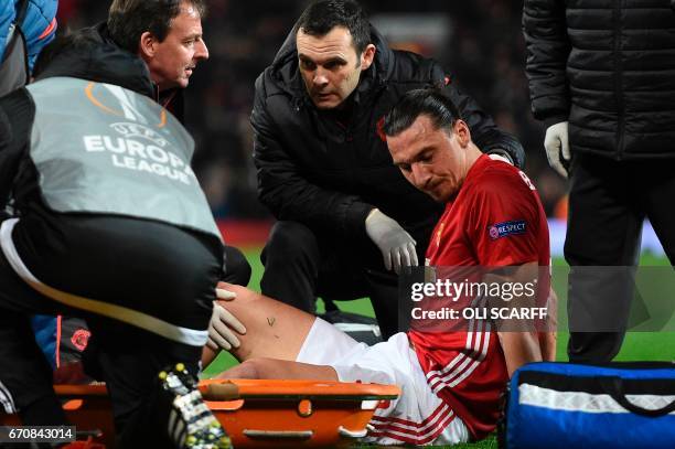 Manchester United's Swedish striker Zlatan Ibrahimovic gets treatment after injuring his knee during the UEFA Europa League quarter-final second leg...