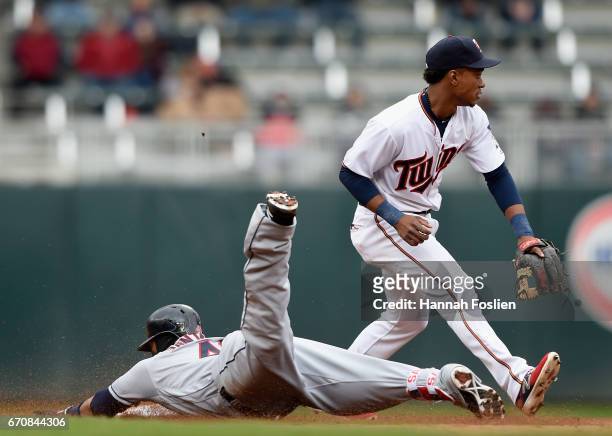 Carlos Santana of the Cleveland Indians slides into second base safely with an RBI double as Jorge Polanco of the Minnesota Twins fields the ball...