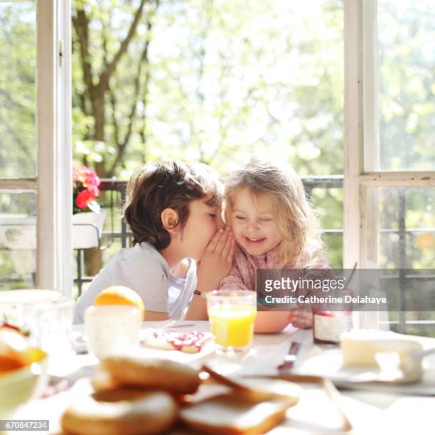 a brother and a sister having their breakfast - fratrie fotografías e imágenes de stock