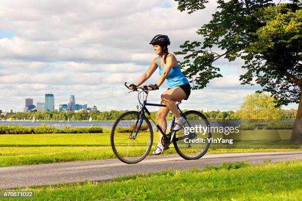 esercizio sano in forma giovane donna ciclismo nel parco urbano della città - pantaloncini foto e immagini stock