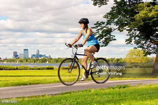 exercício saudável jovem apto andar de bicicleta no parque urbano da cidade - minneapolis street - fotografias e filmes do acervo