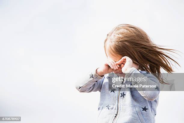 baby girl (18-23 months) shielding face from wind - baby face shield stock pictures, royalty-free photos & images