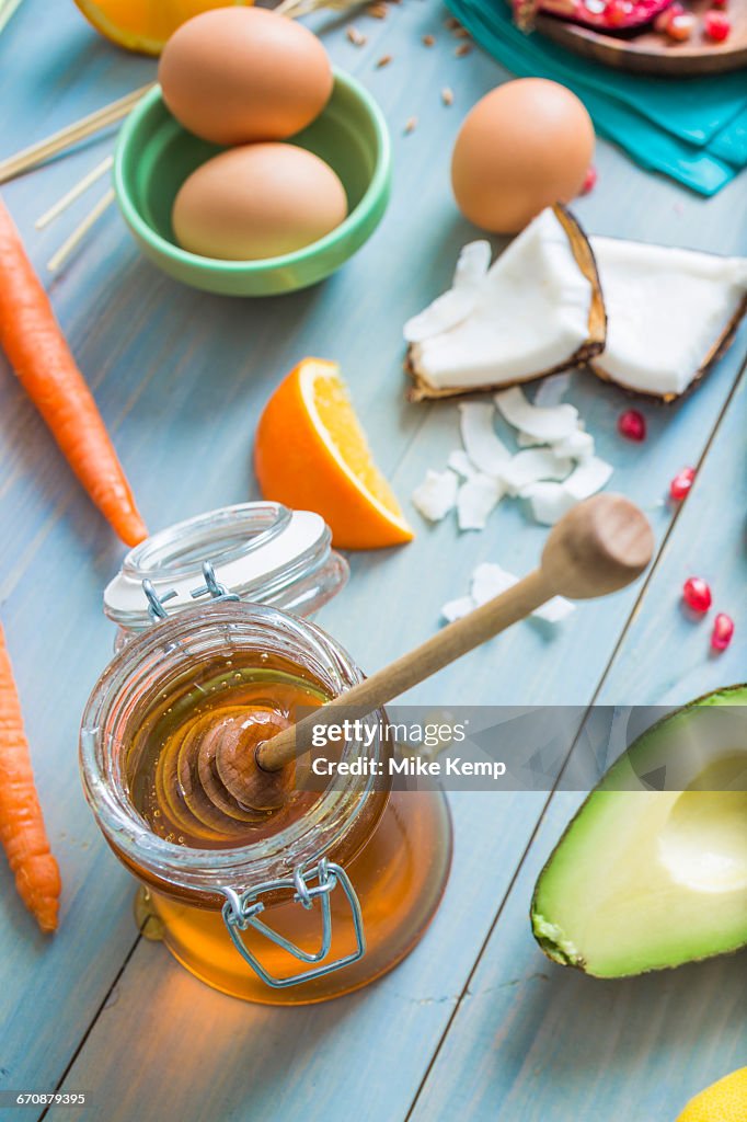 Jar of honey with dipper and fresh ingredients