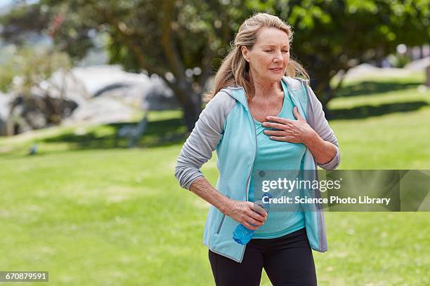 senior woman holding chest in pain - pechos mujer fotografías e imágenes de stock