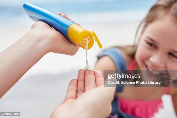 person applying sun cream to a girl - hands sun stock-fotos und bilder