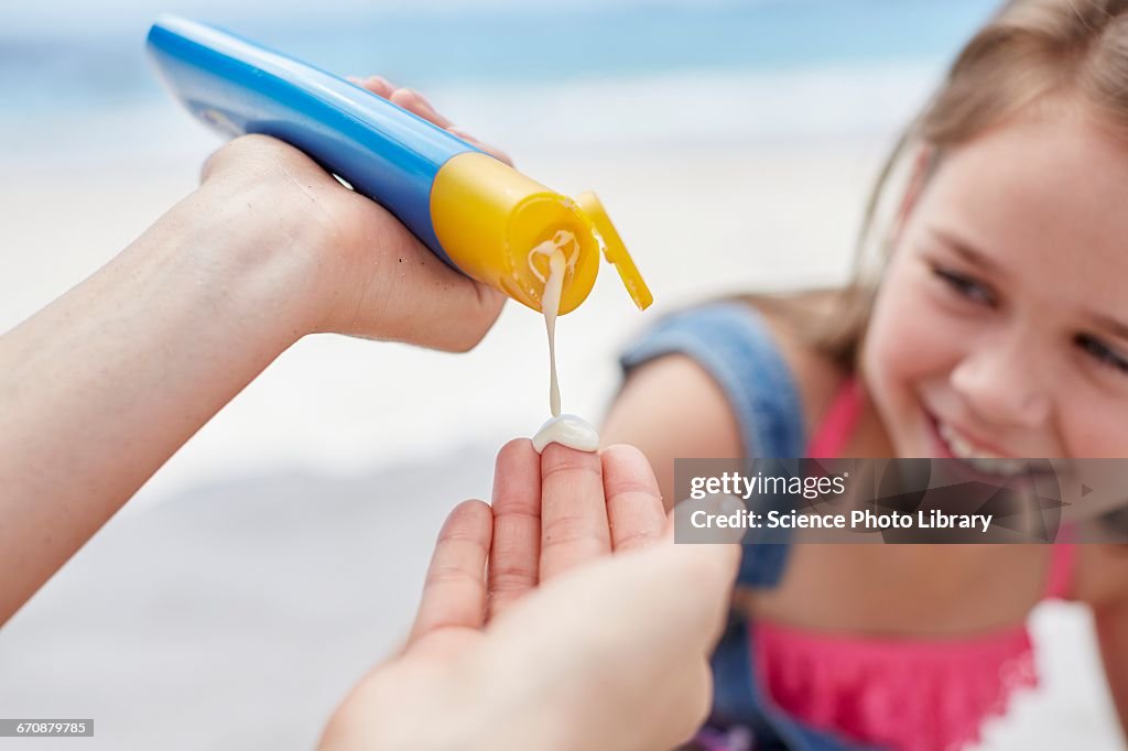 Person applying sun cream to a girl