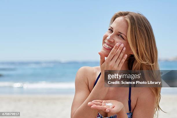 woman applying sun cream on beach - vacation face bildbanksfoton och bilder