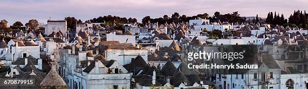 italy, apulia, alberobello, old town panorama of old trulli houses at sunset - trulli photos et images de collection
