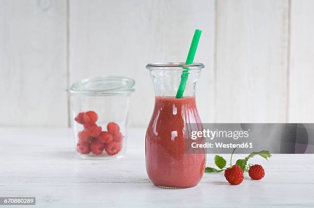 raspberry smoothie in glass with drinking straw - raspberry smoothie stock pictures, royalty-free photos & images