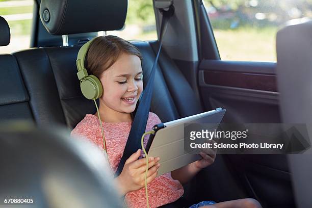 girl wearing headphones - auto tablet stockfoto's en -beelden