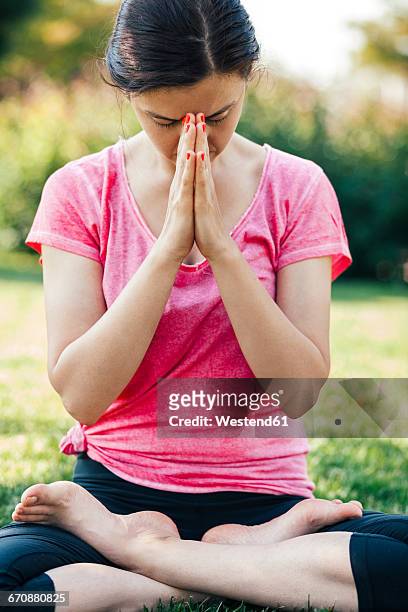 young woman doing yoga, meditation outside, eyes closed - mudra stock-fotos und bilder