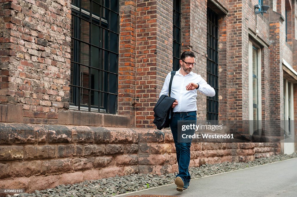 Walking businessman checking the time