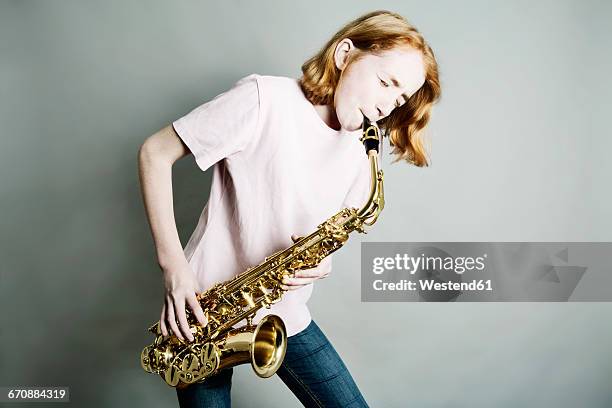 girl playing saxophone - saxophone stock pictures, royalty-free photos & images