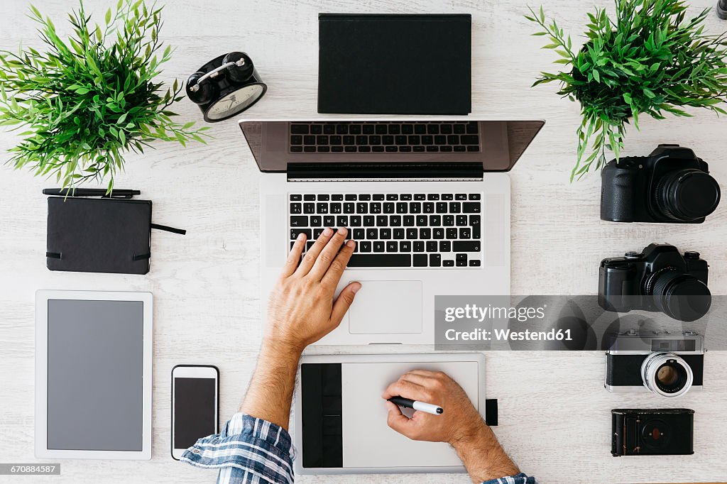 Photographer working at desk with laptop, top view