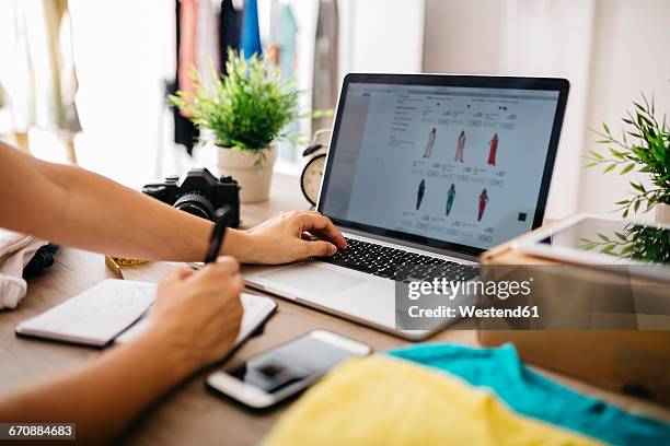 creative professional using laptop at desk - comercio electrónico fotografías e imágenes de stock