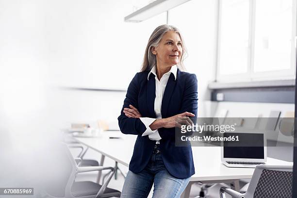 senior businessswoman in conference room - dreiviertelansicht stock-fotos und bilder