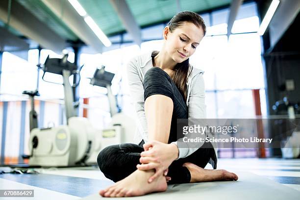 young woman having ankle pain - caviglia foto e immagini stock