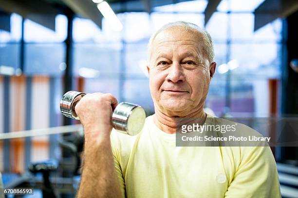 senior man holding dumbbell - musculation des biceps photos et images de collection