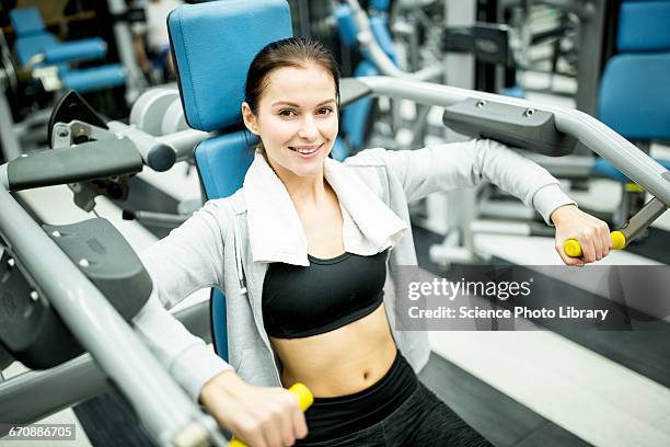 woman using shoulder press machine - shoulder press gym stock pictures, royalty-free photos & images
