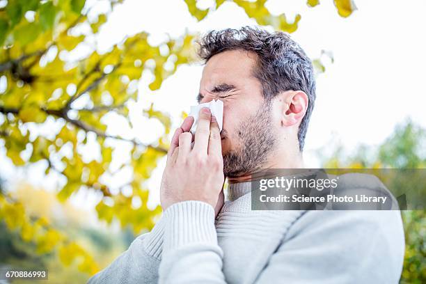young man sneezing - allergia foto e immagini stock