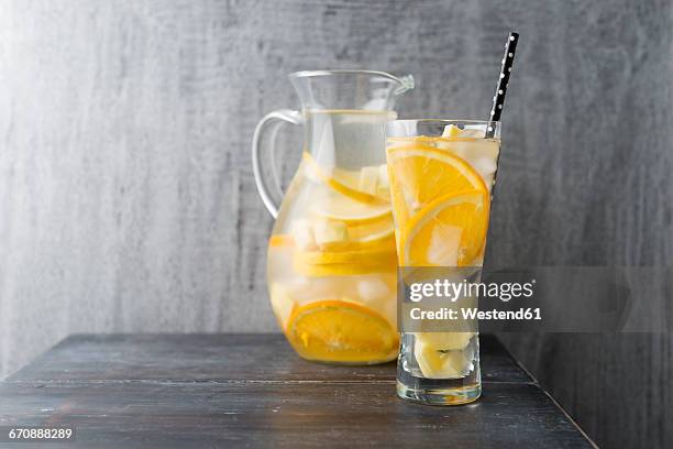 water with lemon, orange and ginger, ice cubes, flavoured - ginger glasses stock-fotos und bilder