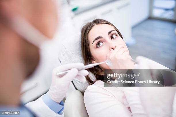 shocked patient in clinic - dentists chair stockfoto's en -beelden