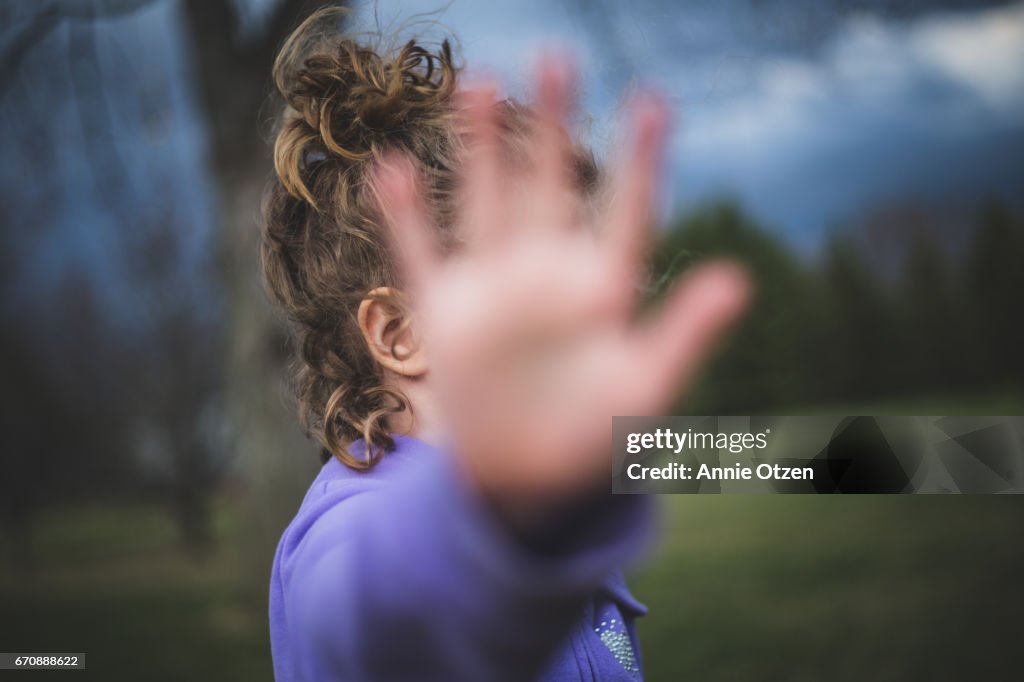 Girl holding hand up to Camera