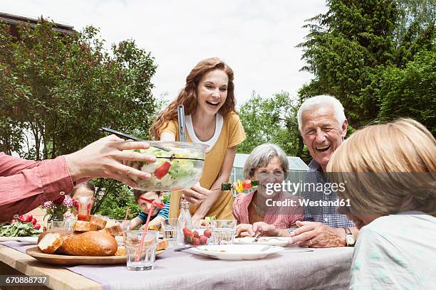 happy extended family dining in garden - family barbeque garden stock pictures, royalty-free photos & images