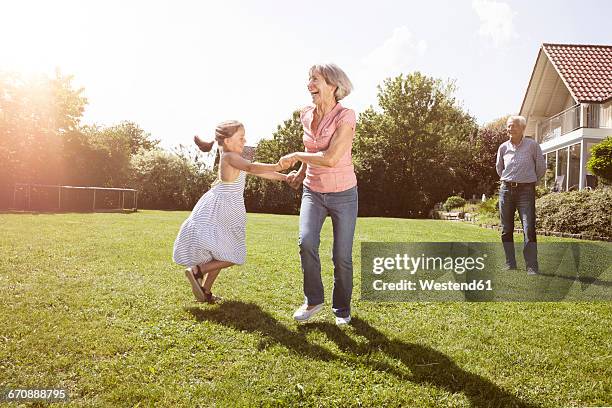 playful grandmother with granddaughter in garden - child animated watching stock-fotos und bilder