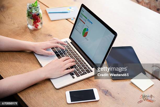 woman at desk using laptop working on calculation - autonomo smartphone tablet fotografías e imágenes de stock