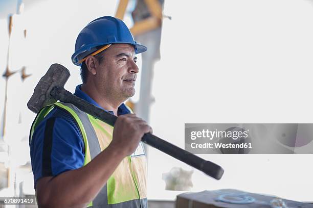 confident construction worker with sledgehammer - vorschlaghammer stock-fotos und bilder