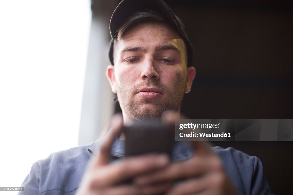 Mechanic looking at cell phone