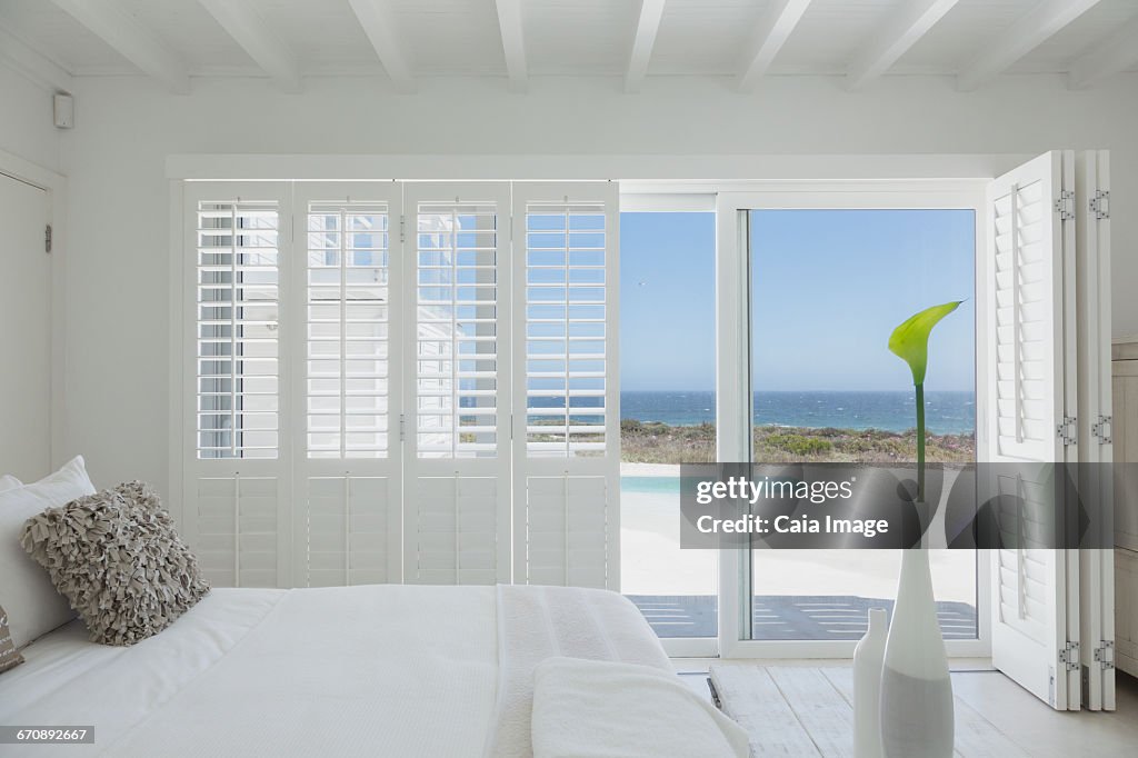 White bedroom home showcase open to swimming pool and ocean view