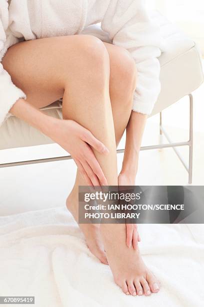 young woman rubbing leg and ankle - �足首 ストックフォトと画像