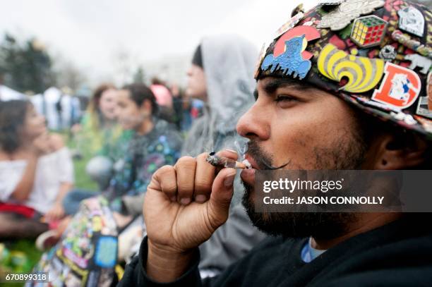 Satan Valerio smokes a joint during the Denver 420 Rally at Civic Center Park in Denver, Colorado on April 20, 2017. - The rally, held annually, is a...