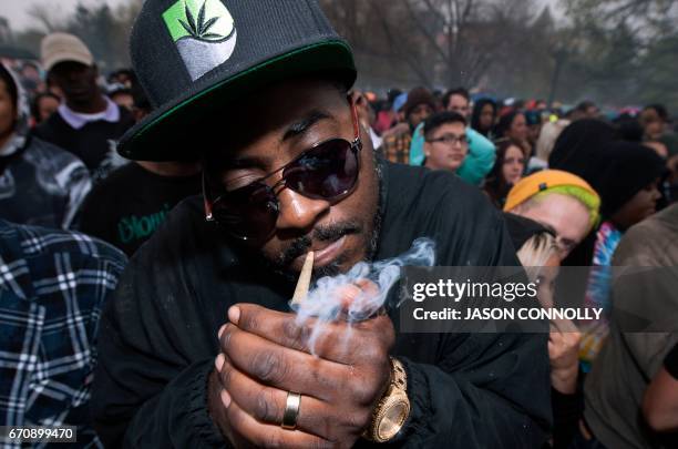 Mo Banez, of Austin, Texas, lights a joint during the Denver 420 Rally at Civic Center Park in Denver, Colorado on April 20, 2017. The rally, held...