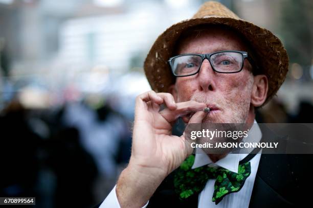 James Reed smokes a joint during the Denver 420 Rally at Civic Center Park in Denver, Colorado on April 20, 2017. The rally, held annually, is a...