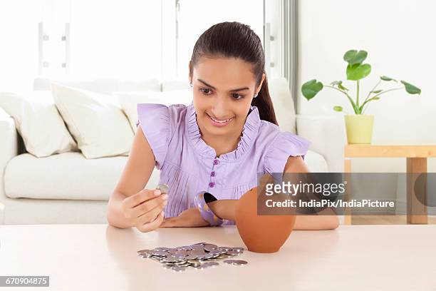 heap of coins and a money bank in front of a teenage girls - gullak bildbanksfoton och bilder
