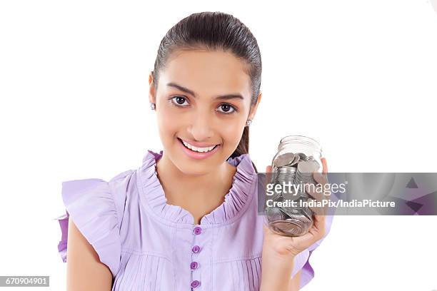 a teenage girls with a jar filled with coins - gullak stock-fotos und bilder