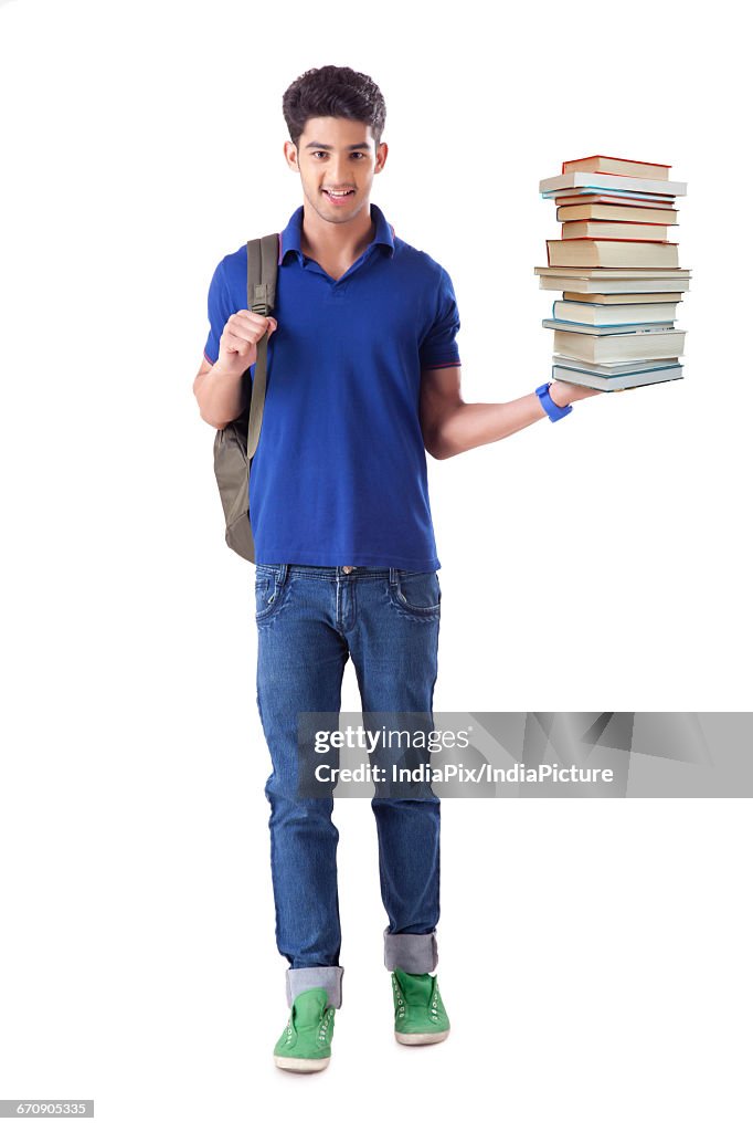 Young Man Standing With Stack of books in hand, isolated on white background