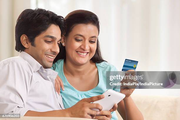 happy couple shopping online using mobile. - onlineshopping ストックフォトと画像