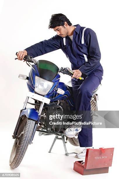 mechanic working on motorcycle - image technique fotografías e imágenes de stock