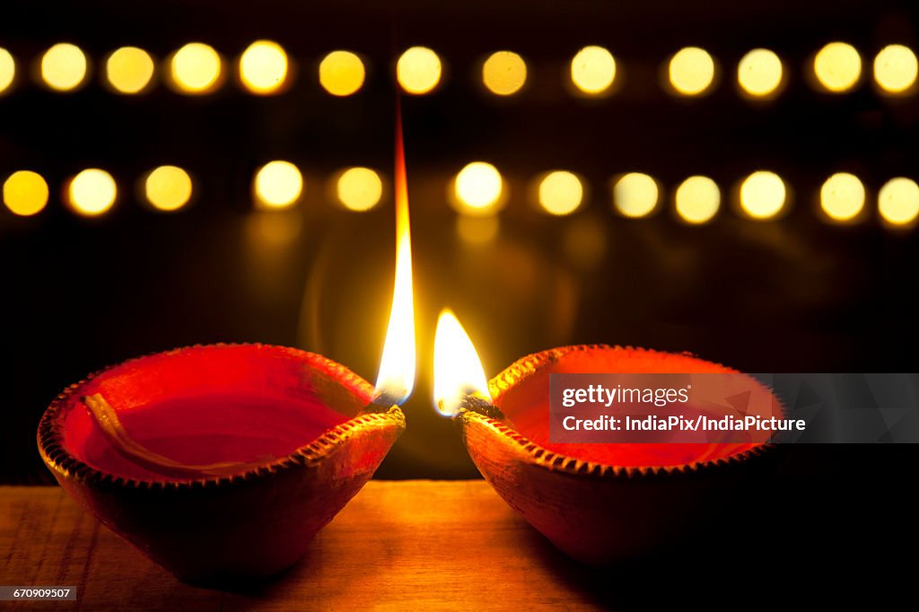 Two earthen lamps lit for festival